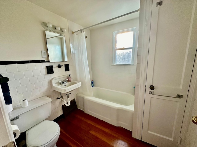 bathroom with hardwood / wood-style flooring, toilet, tile walls, and shower / bathtub combination with curtain