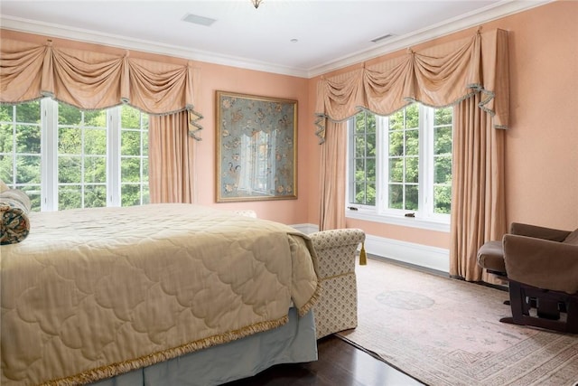 bedroom featuring baseboards, ornamental molding, and visible vents