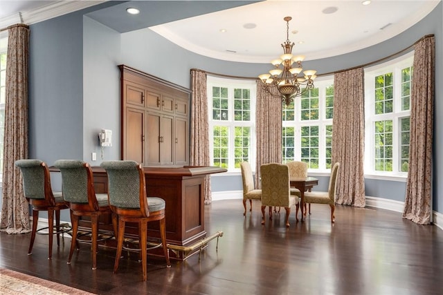 dining area with baseboards, an inviting chandelier, dark wood-style flooring, ornamental molding, and a dry bar