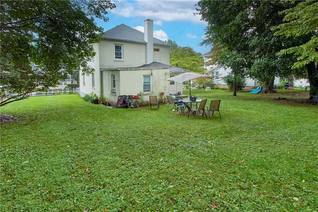 rear view of property featuring a lawn