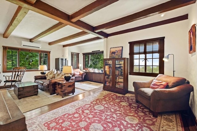 living room featuring beamed ceiling, hardwood / wood-style floors, and an AC wall unit