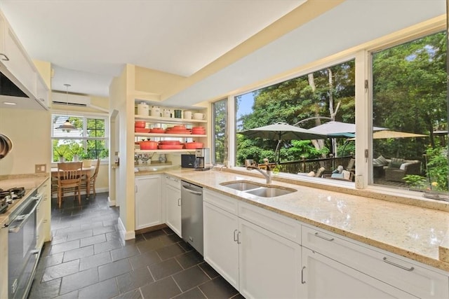 kitchen featuring appliances with stainless steel finishes, white cabinetry, and light stone counters