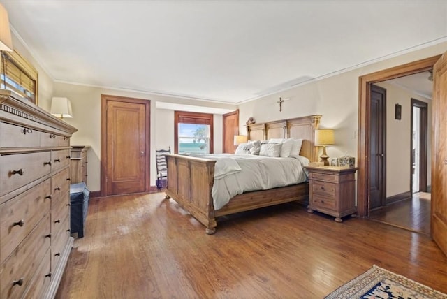 bedroom featuring ornamental molding and dark wood-type flooring