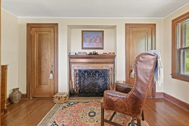 sitting room with crown molding and hardwood / wood-style flooring