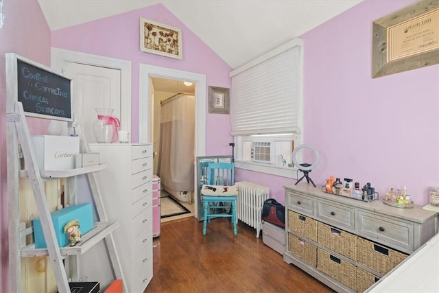 bedroom with radiator heating unit, dark hardwood / wood-style flooring, vaulted ceiling, and cooling unit