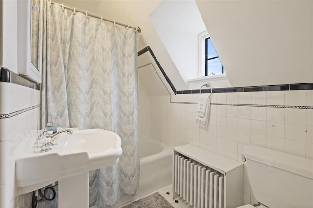 bathroom with radiator heating unit, tile patterned floors, tile walls, toilet, and shower / tub combo