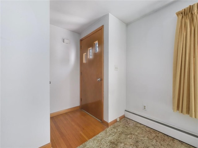 entrance foyer with light wood-type flooring and a baseboard radiator