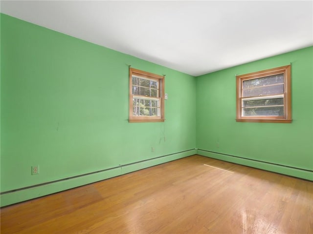 empty room featuring light hardwood / wood-style floors and a baseboard radiator