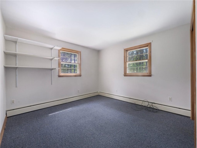 empty room featuring a healthy amount of sunlight, carpet floors, and a baseboard heating unit