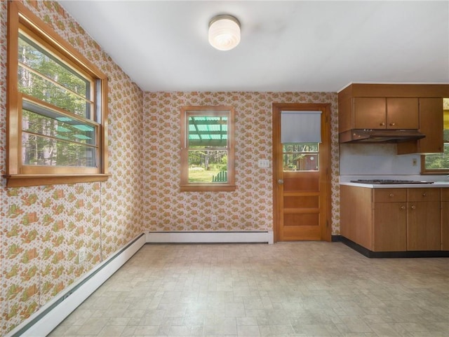 1124 State Route 42, Sparrowbush, NY 12780 - kitchen featuring under cabinet range hood, baseboard heating, wallpapered walls, brown cabinets, and light countertops