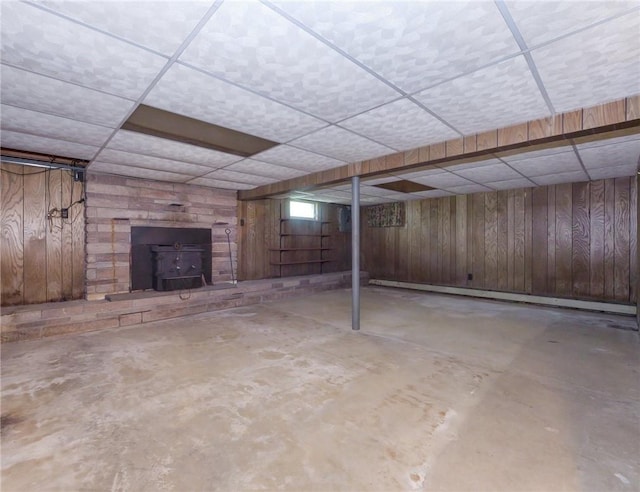 1124 State Route 42, Sparrowbush, NY 12780 - finished below grade area with a drop ceiling, wooden walls, a wood stove, and a baseboard heating unit