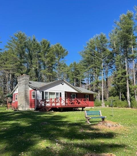 1124 State Route 42, Sparrowbush, NY 12780 - view of front of house featuring a front yard, a chimney, a deck, and view of wooded area