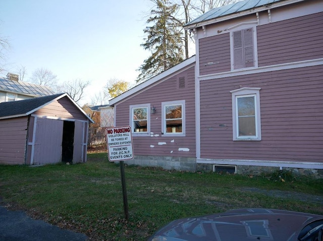 view of home's exterior featuring a yard and a storage unit