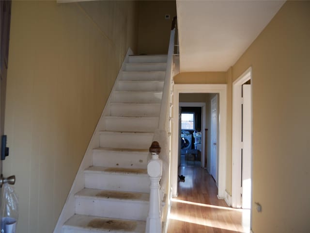 stairs with wood-type flooring and washer / clothes dryer