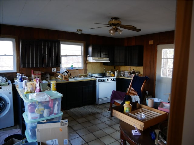 kitchen featuring extractor fan, ceiling fan, sink, washer / dryer, and white gas stove