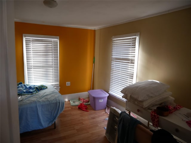 bedroom featuring ornamental molding and hardwood / wood-style flooring