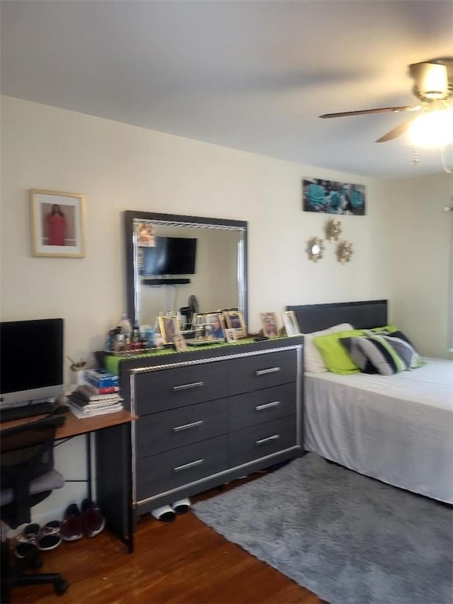 bedroom with dark hardwood / wood-style flooring and ceiling fan