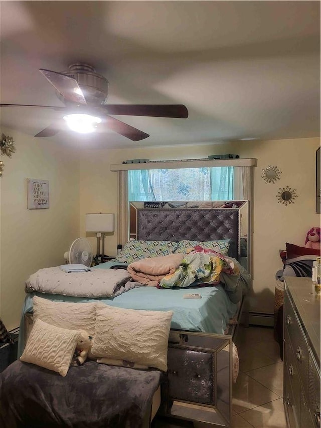 bedroom featuring baseboard heating, ceiling fan, and light tile patterned flooring