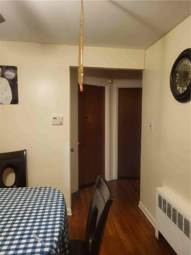 bedroom with radiator heating unit and dark hardwood / wood-style floors