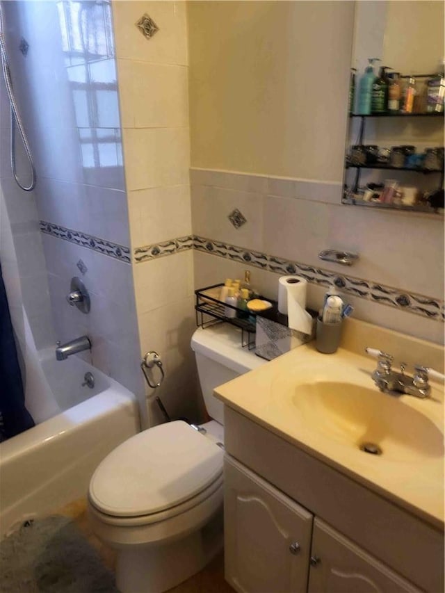 full bathroom with vanity, toilet, shower / bath combo with shower curtain, and tile walls