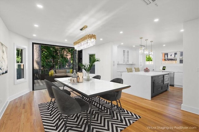 dining area featuring an inviting chandelier and light wood-type flooring