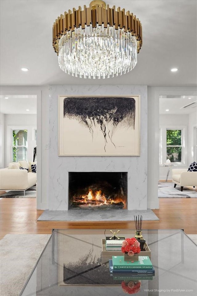 interior details featuring a high end fireplace, hardwood / wood-style floors, and an inviting chandelier