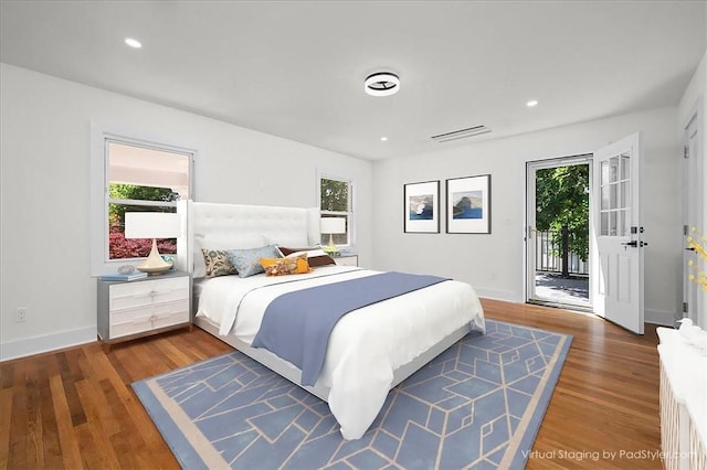 bedroom featuring multiple windows, dark wood-type flooring, and access to exterior