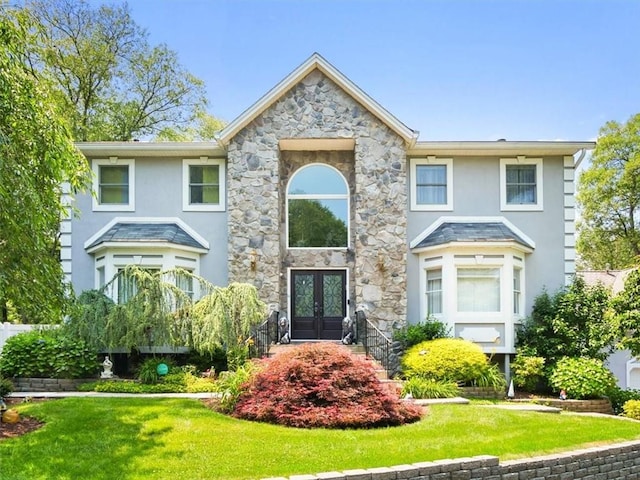 view of front of home with a front yard and french doors