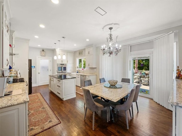 dining room with dark hardwood / wood-style flooring, ornamental molding, sink, and an inviting chandelier