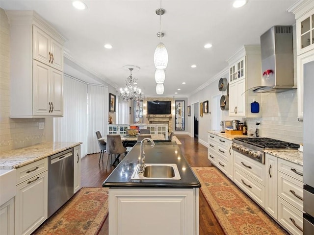 kitchen with white cabinets, sink, wall chimney exhaust hood, ornamental molding, and stainless steel appliances