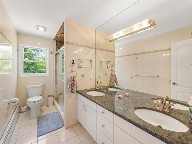 bathroom with tile patterned floors, vanity, a baseboard radiator, and a shower with shower door