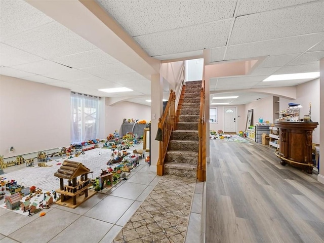 rec room featuring hardwood / wood-style floors and a drop ceiling