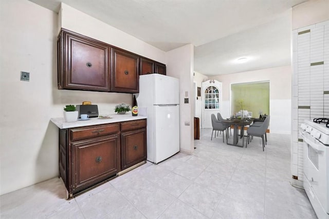 kitchen with dark brown cabinets and white appliances