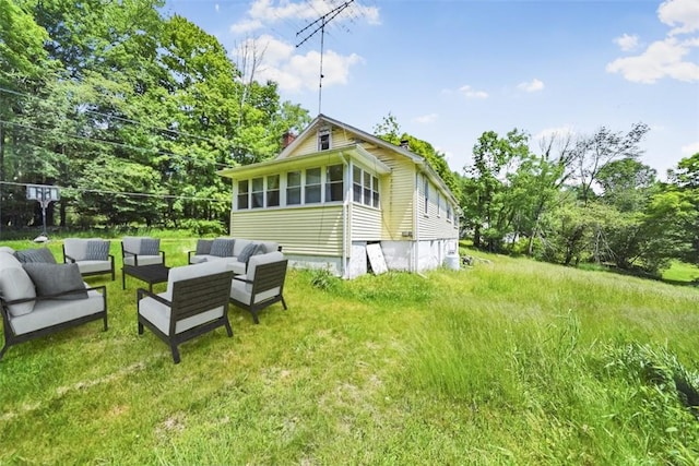 back of house featuring a sunroom and an outdoor living space