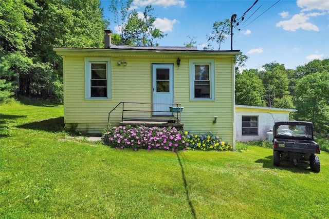 rear view of property featuring a lawn