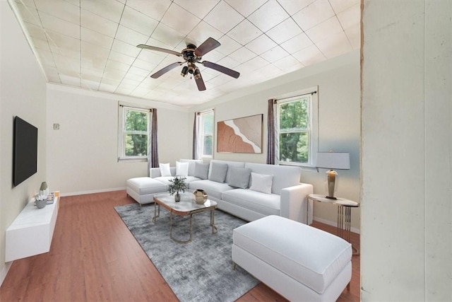 living room featuring ceiling fan, ornamental molding, and hardwood / wood-style flooring