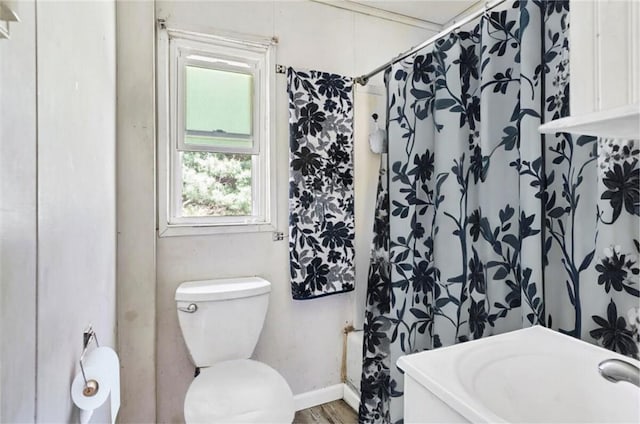 bathroom with wood-type flooring, toilet, and curtained shower