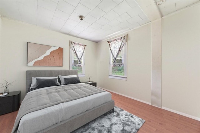 bedroom with hardwood / wood-style floors and ornamental molding