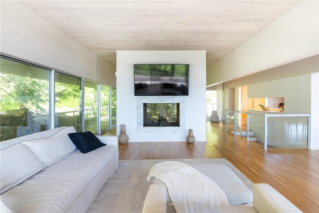 living room with a healthy amount of sunlight, wooden ceiling, and light hardwood / wood-style flooring