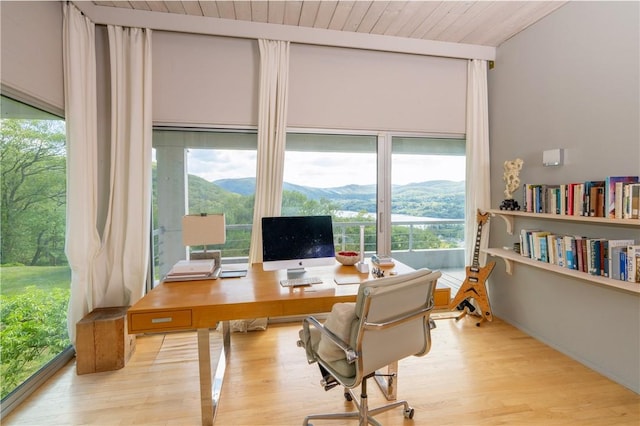 office area with light hardwood / wood-style floors and wood ceiling