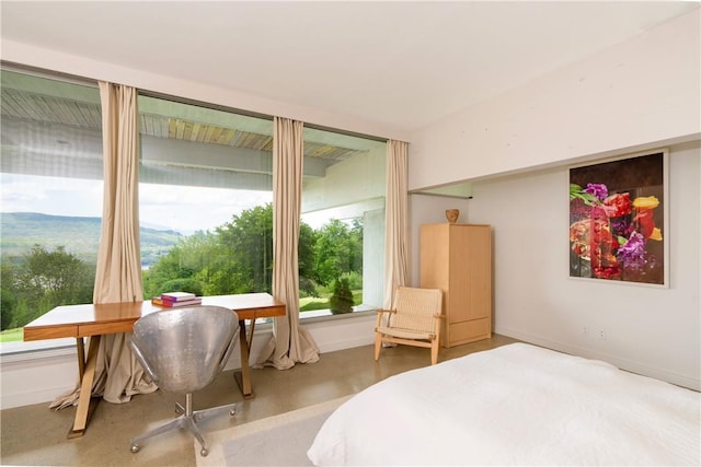 carpeted bedroom featuring a mountain view and multiple windows