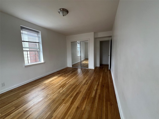 unfurnished bedroom featuring dark hardwood / wood-style floors and a closet