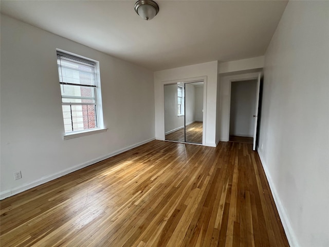 unfurnished bedroom with dark wood-type flooring and a closet