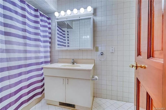 bathroom with tile patterned flooring, vanity, and tile walls