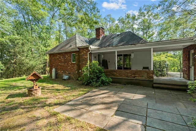 rear view of property featuring a patio area and a yard