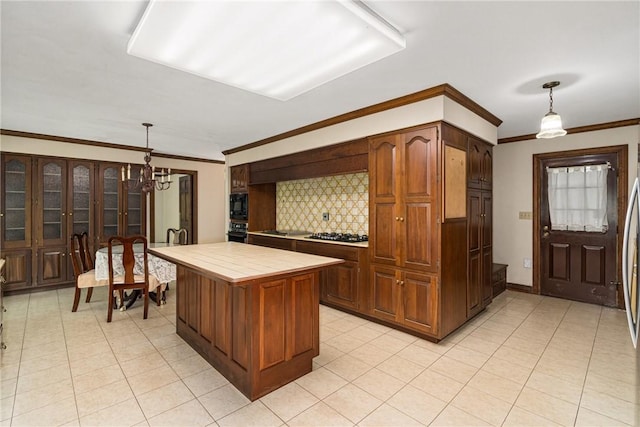 kitchen featuring pendant lighting, black appliances, decorative backsplash, tile counters, and a chandelier