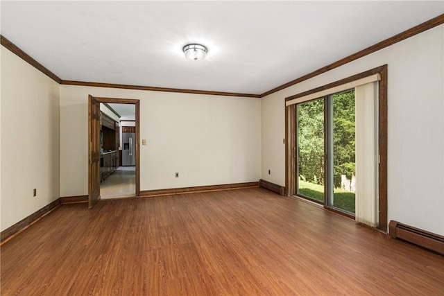 empty room with hardwood / wood-style flooring, baseboard heating, and a wealth of natural light