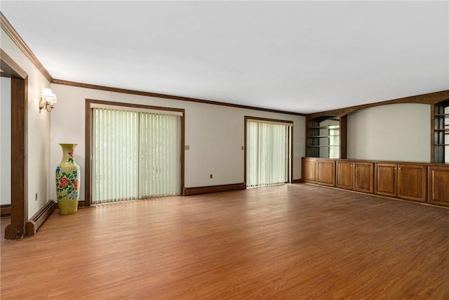 unfurnished living room featuring light hardwood / wood-style flooring, a baseboard heating unit, and ornamental molding