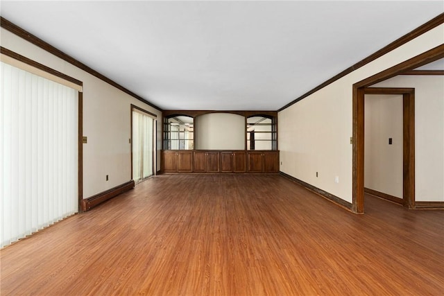 empty room with hardwood / wood-style floors, crown molding, and a baseboard heating unit