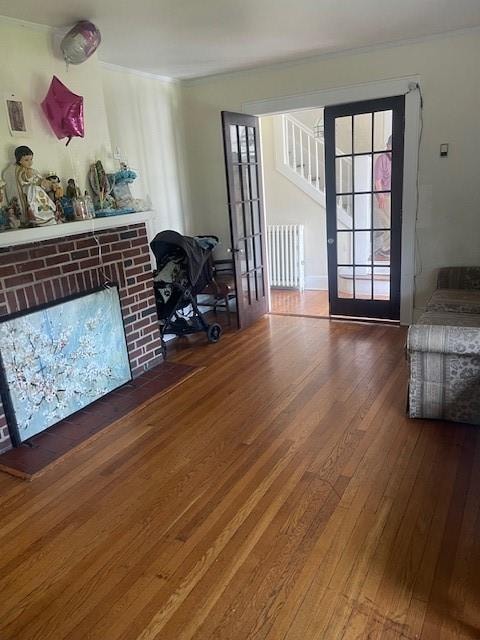 living room with radiator heating unit, dark wood-type flooring, and french doors